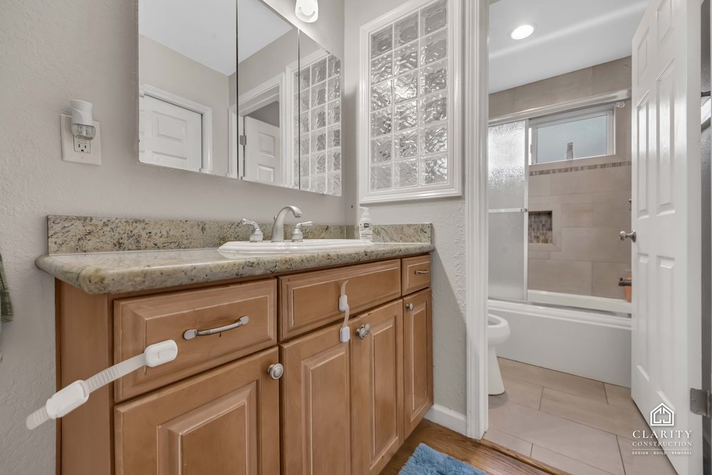 Before: the hall bath with its oak vanity, built-in tub and sliding shower door