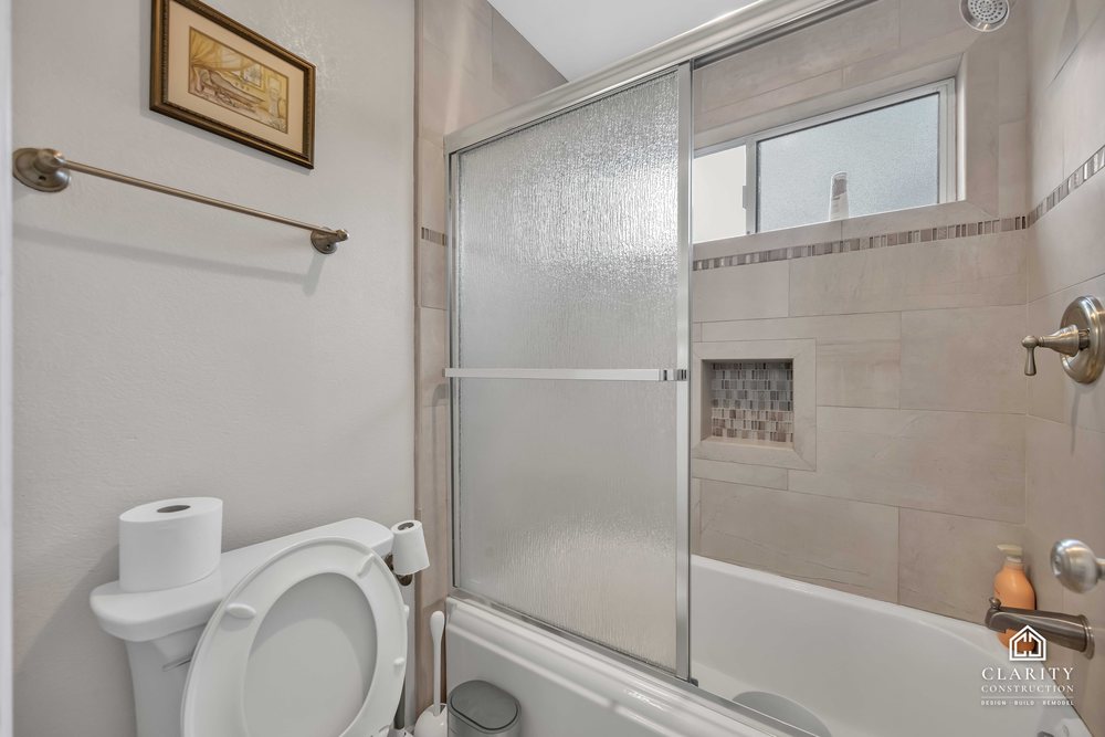 Before: the hall bath with its oak vanity, built-in tub and sliding shower door