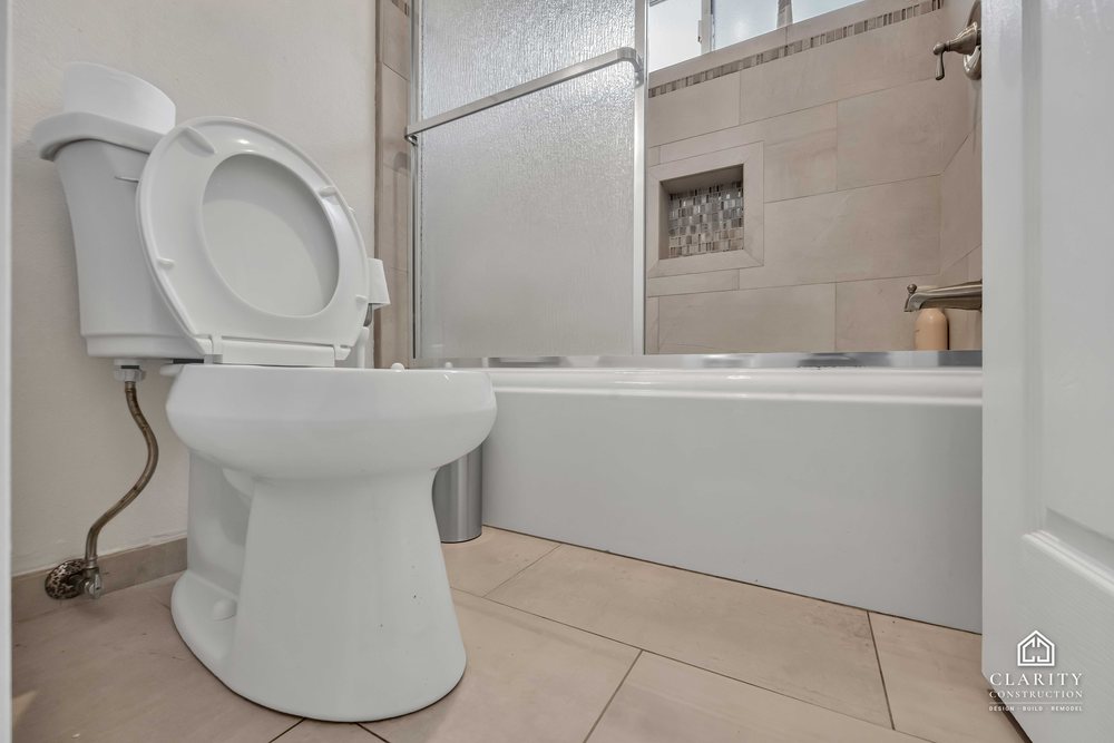 Before: the hall bath with its oak vanity, built-in tub and sliding shower door
