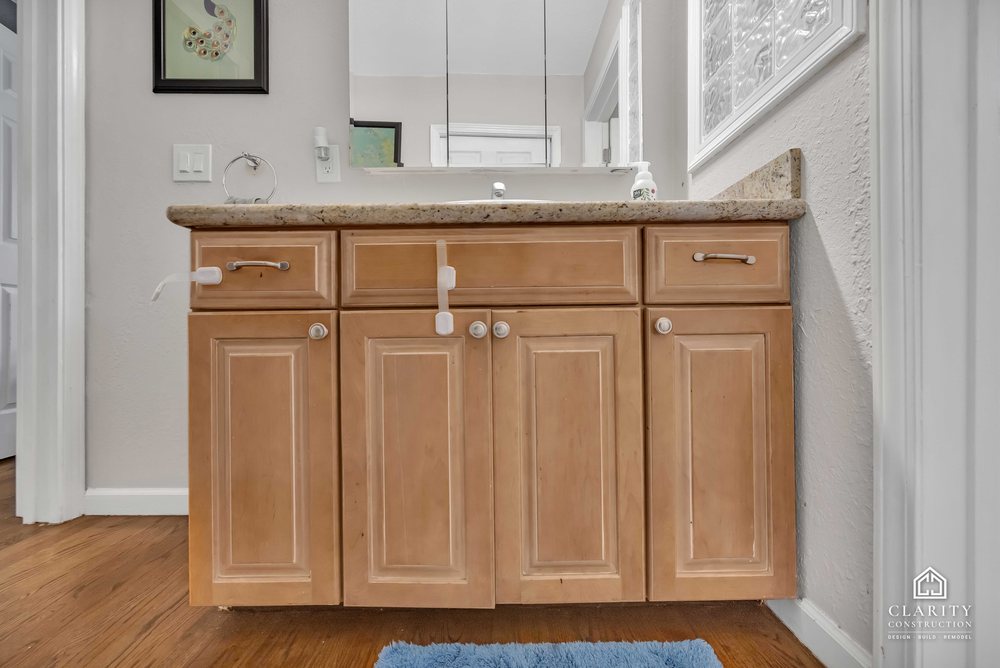 Before: the hall bath with its oak vanity, built-in tub and sliding shower door